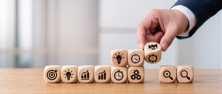 Businessman hand arranging wooden cubes with icon of time management concept.の素材