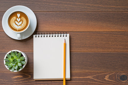 Coffee cup with notebook and pencil on the wooden table.の素材