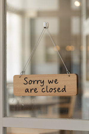 \Wooden sign with text \"\"Sorry we are closed\"\" hanging on the glass door\""の素材