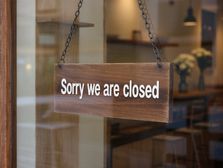 \Wooden sign with text \"\"Sorry we are closed\"\" hanging on the door of a cafe\""の素材