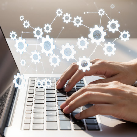 Hand typing on laptop keyboard with gear icons on screen. Business and technology conceptの素材