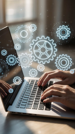 Businessman working on laptop in office with gear icons and cogwheelsの素材