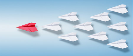 Leadership concept. Red paper plane leading group of white paper planes.の素材