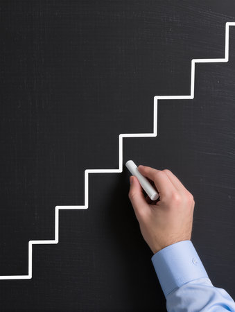Businessman drawing stairs on blackboard, closeup. Success conceptの素材