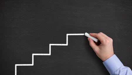 Hand drawing stairs to success on blackboard. Business success concept.の素材