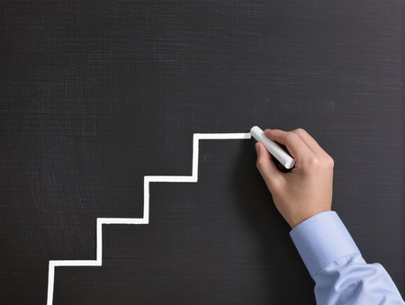 Businessman drawing stairs on blackboard, closeup. Success conceptの素材