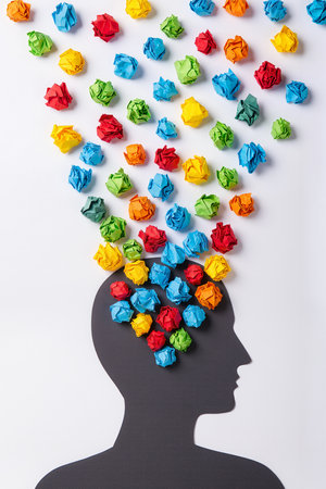 Silhouette of a man with multicolored paper balls in his headの素材