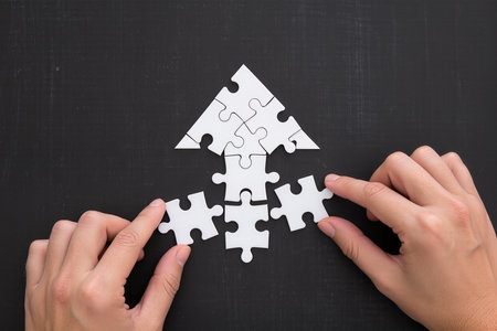 Hands connecting jigsaw puzzle pieces. Business solutions and strategy conceptの素材
