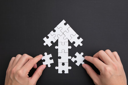 Jigsaw puzzle piece on black background with copy space. Business conceptの素材