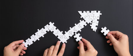 Hands connecting jigsaw puzzle pieces. Business success and strategy conceptの素材