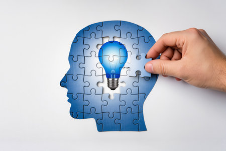 Human head with lightbulb made of puzzle pieces on white backgroundの素材