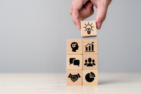 Wooden blocks with icons of business, finance, management and marketing.の素材