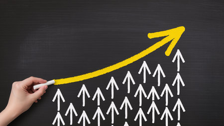 Hand drawing increasing arrow on blackboard, concept of increasing sales.の素材