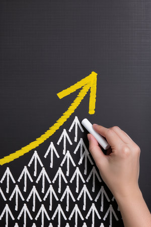 Hand drawing increasing arrow on blackboard, business success and growth conceptの素材