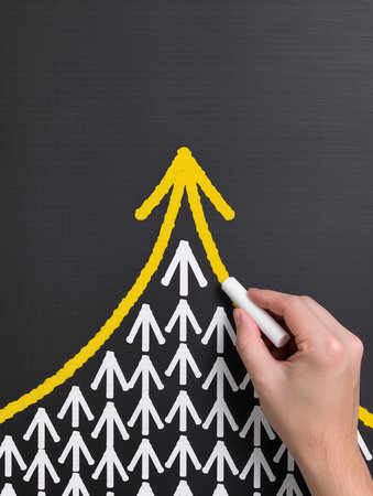 hand drawing a chart with white arrows on blackboard, business conceptの素材