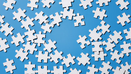 White jigsaw puzzle pieces on blue background. Copy space for textの素材
