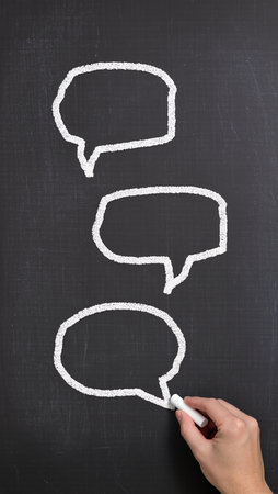 Chalk drawing of speech bubbles on blackboard, close-upの素材