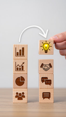 Businessman hand arranging wooden block with business icons on top of wooden cube.の素材
