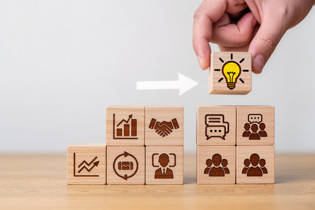 Businessman hand arranging wood block stacking as step stair and light bulb icon on wooden cube, business conceptの素材