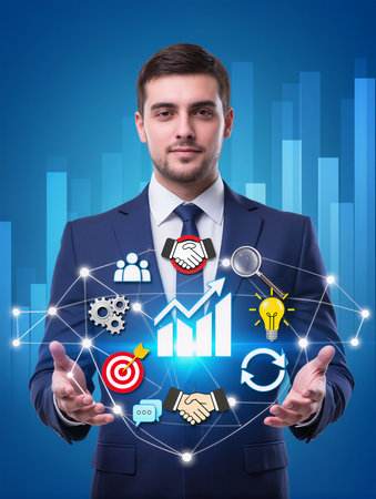 Businessman in suit holding digital interface with business icons over blue backgroundの素材