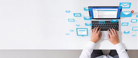 Businessman using laptop with social media icons on white background, top viewの素材