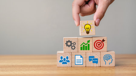 Businessman hand arranging wooden cube with light bulb icon on top of wooden cube, business success conceptの素材