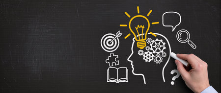 Idea concept with a person drawing a bulb on a blackboardの素材