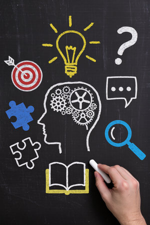 A man's hand is drawing a business idea sketch on a blackboard.の素材