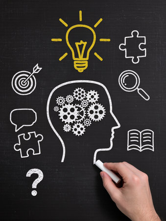 Human head with gears and lightbulb drawn on a blackboardの素材