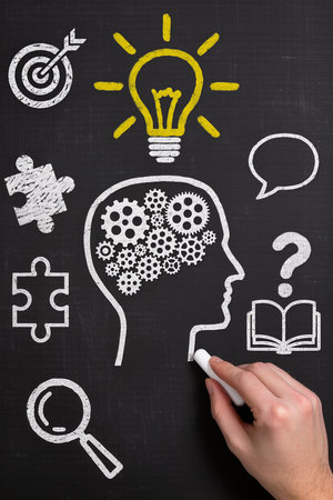 Idea concept on a blackboard with a chalk in the handの素材