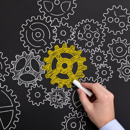Teamwork concept on blackboard with businessman hand drawing yellow gear wheelの素材