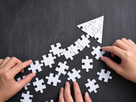Close up of business people hands assembling jigsaw puzzle with missing pieceの素材