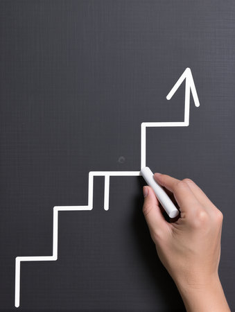 Hand drawing a chart on a blackboard with white chalk - business conceptの素材
