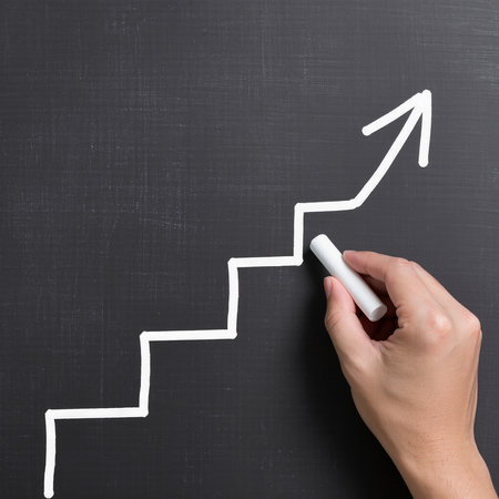 Hand drawing a white arrow on blackboard, success and growth conceptの素材