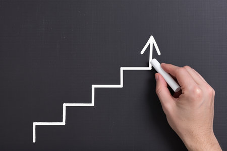 Hand drawing a chart on blackboard, concept of success and growthの素材