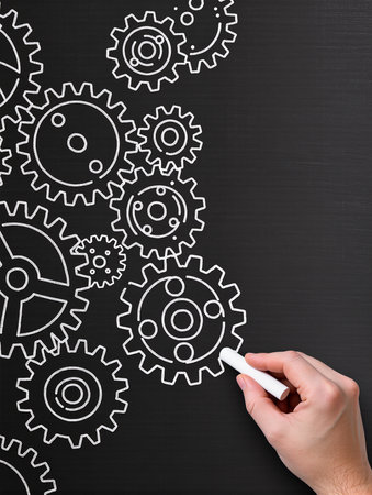 Hand drawing gears on blackboard, close-up. Teamwork conceptの素材