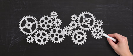Teamwork concept with gears and cogwheels on a blackboardの素材