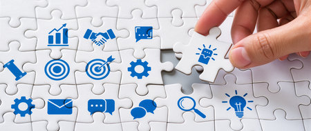 Hand of businesswoman completing the puzzle with missing piece to find solutionの素材