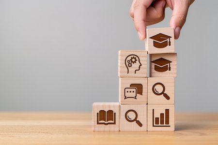 Conceptual image of business people stacking wooden blocks with icons.の素材