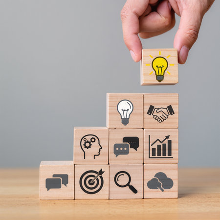 Hand of businessman arranging wooden block stacking as step stair and light bulb icon on wood block, business growth conceptの素材