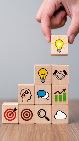 Hand arranging wooden cube with business icon on top, success and strategy conceptの素材