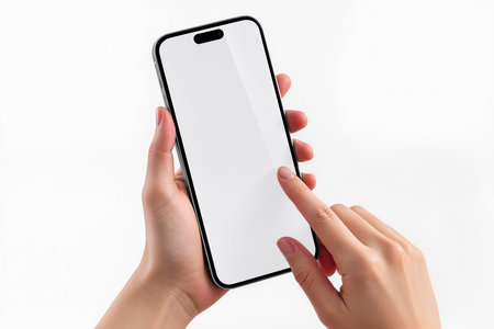 Female hands holding a smartphone with white screen isolated on white background.の素材