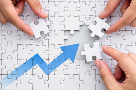 Close-up Of Person's Hand Connecting Jigsaw Puzzle With Blue Arrowの素材