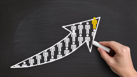 Business graph on blackboard with hand drawing a group of people.の素材