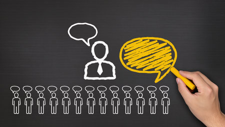 businessman drawing a group of people with a yellow marker on blackboardの素材