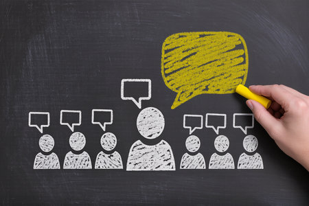 People with speech bubbles on blackboard, closeup of hand drawingの素材