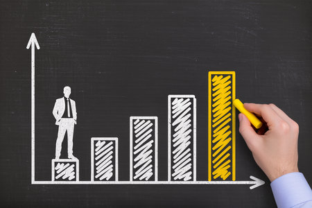 businessman drawing graph on blackboard with yellow marker, success conceptの素材