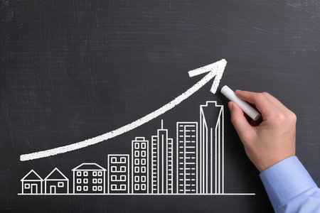 Businessman drawing a growing graph on blackboard, close-upの素材