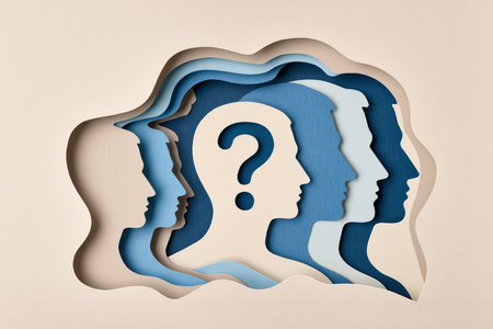 Paper cut of human head with question mark on paper background. Conceptual imageの素材