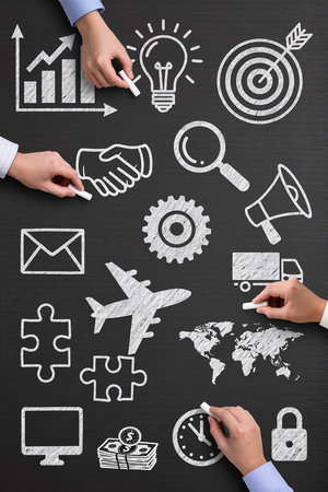 Top view of business people hands drawing business strategy plan on blackboardの素材